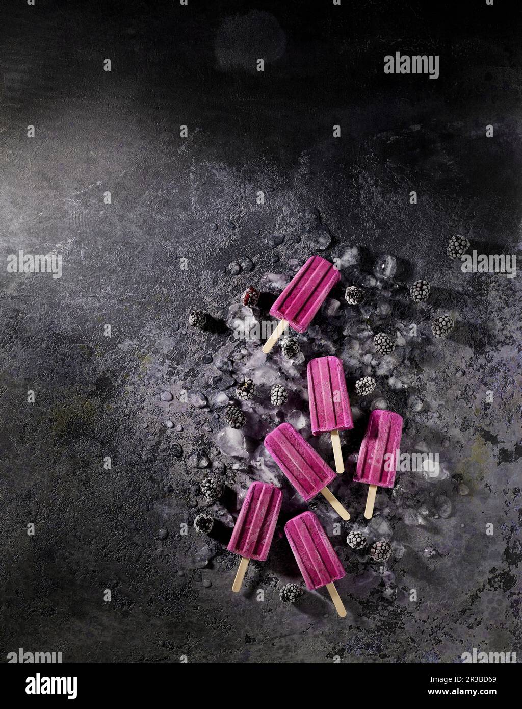 Popsicles di yogurt di blackberry fatti in casa su uno sfondo grigio Foto Stock