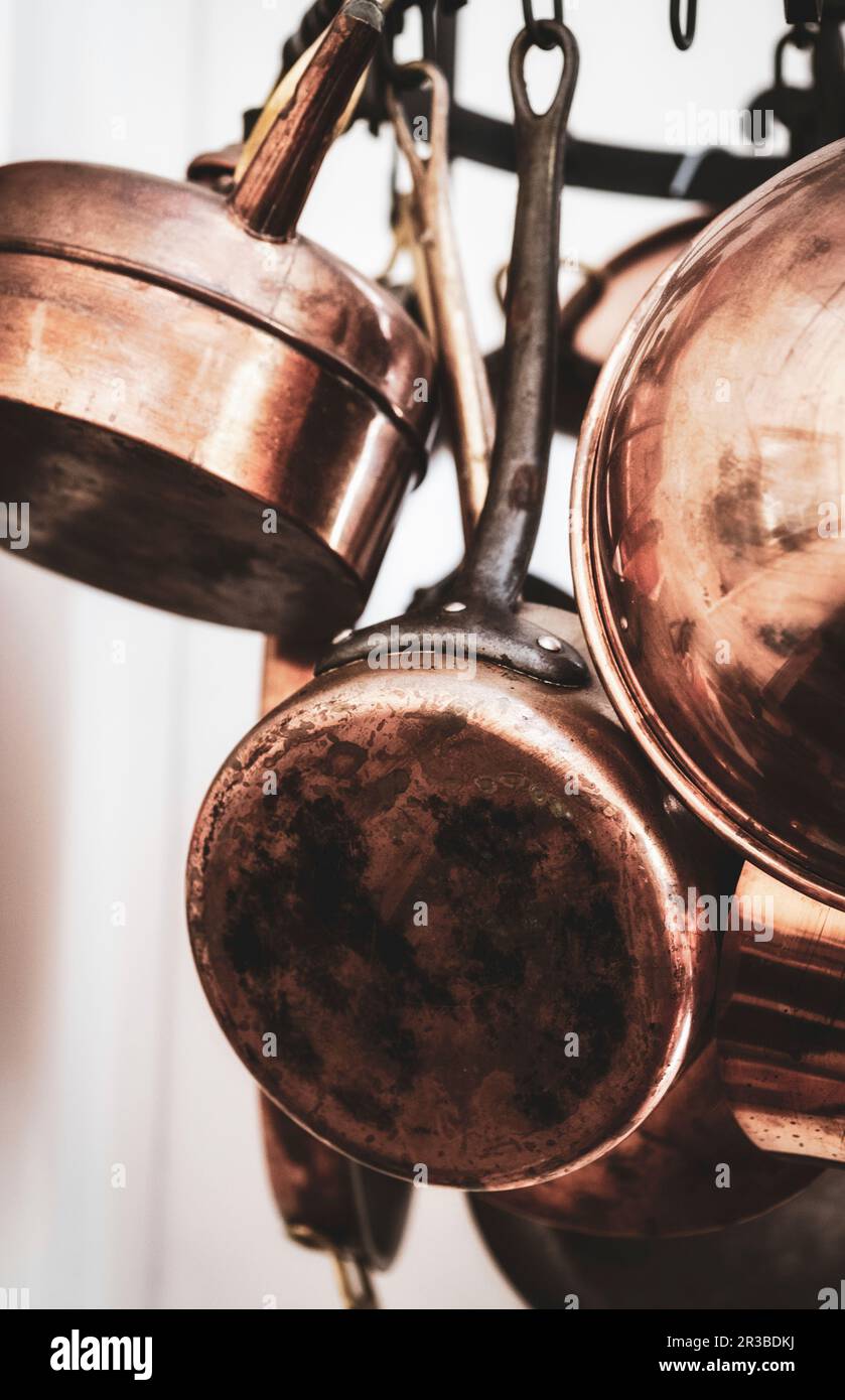Pentole di rame in cucina su una corona appesa Foto Stock