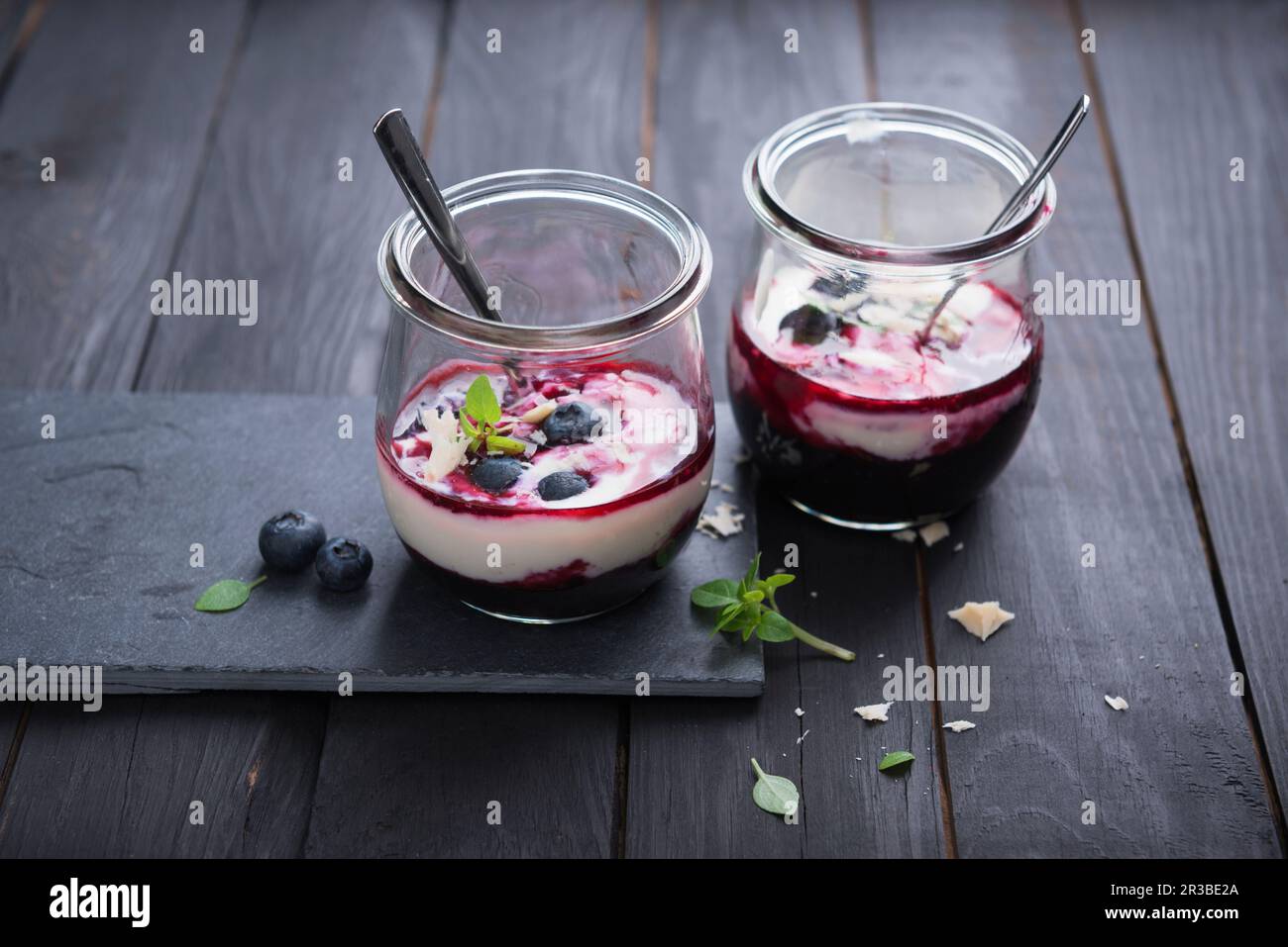Yogurt di mandorle con composta di mirtillo in un bicchiere Foto Stock