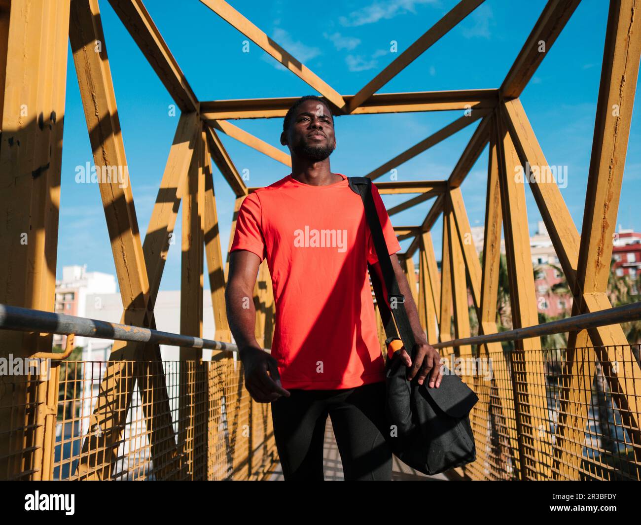 Atleta con borsa da palestra ponte pedonale Foto Stock