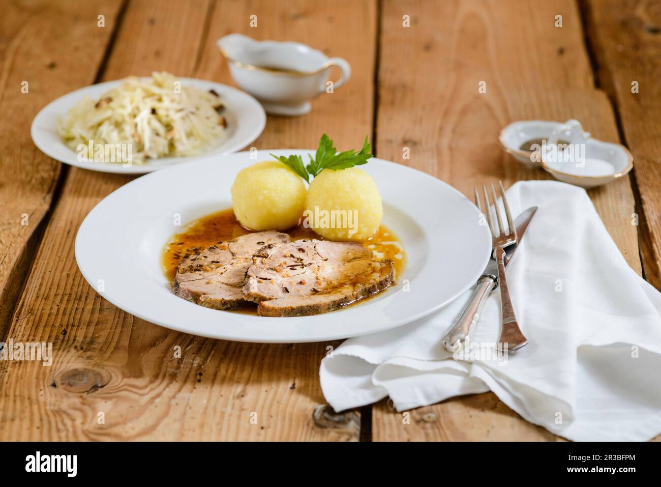 Maiale arrosto a fette con gnocchi di patate e cavolo Foto Stock