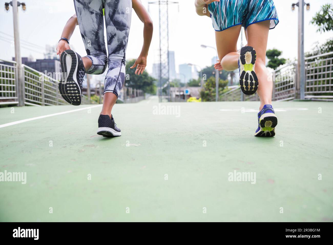 Donne che indossano scarpe sportive che corrono sul sentiero Foto Stock