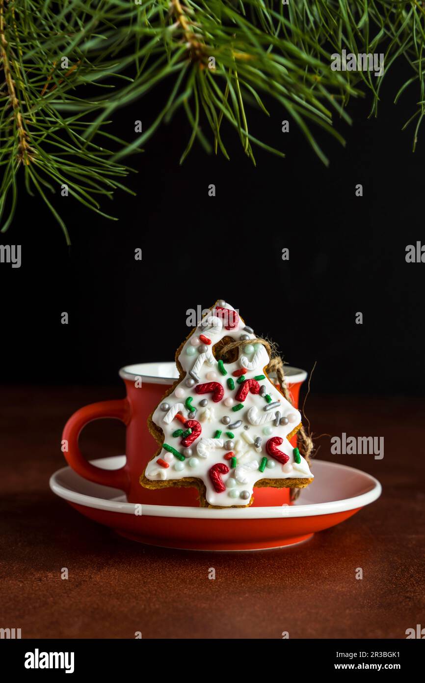 Biscotto di pan di zenzero dell'albero di Natale decorato con gli spruzzi dello zucchero e la glassa Foto Stock