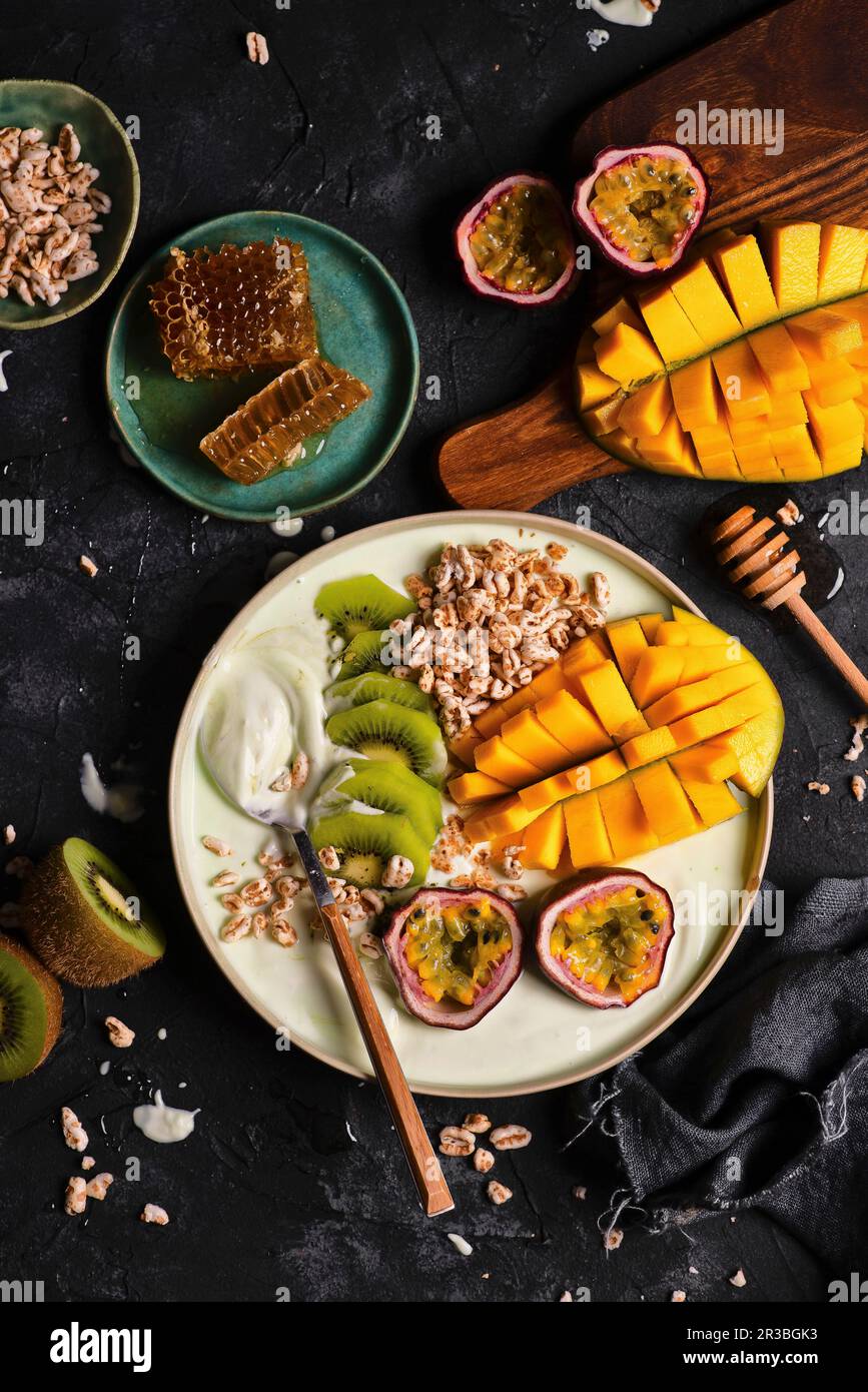 Ciotola di frullato con matcha, mango, frutto della passione, kiwi e spelled espanso Foto Stock