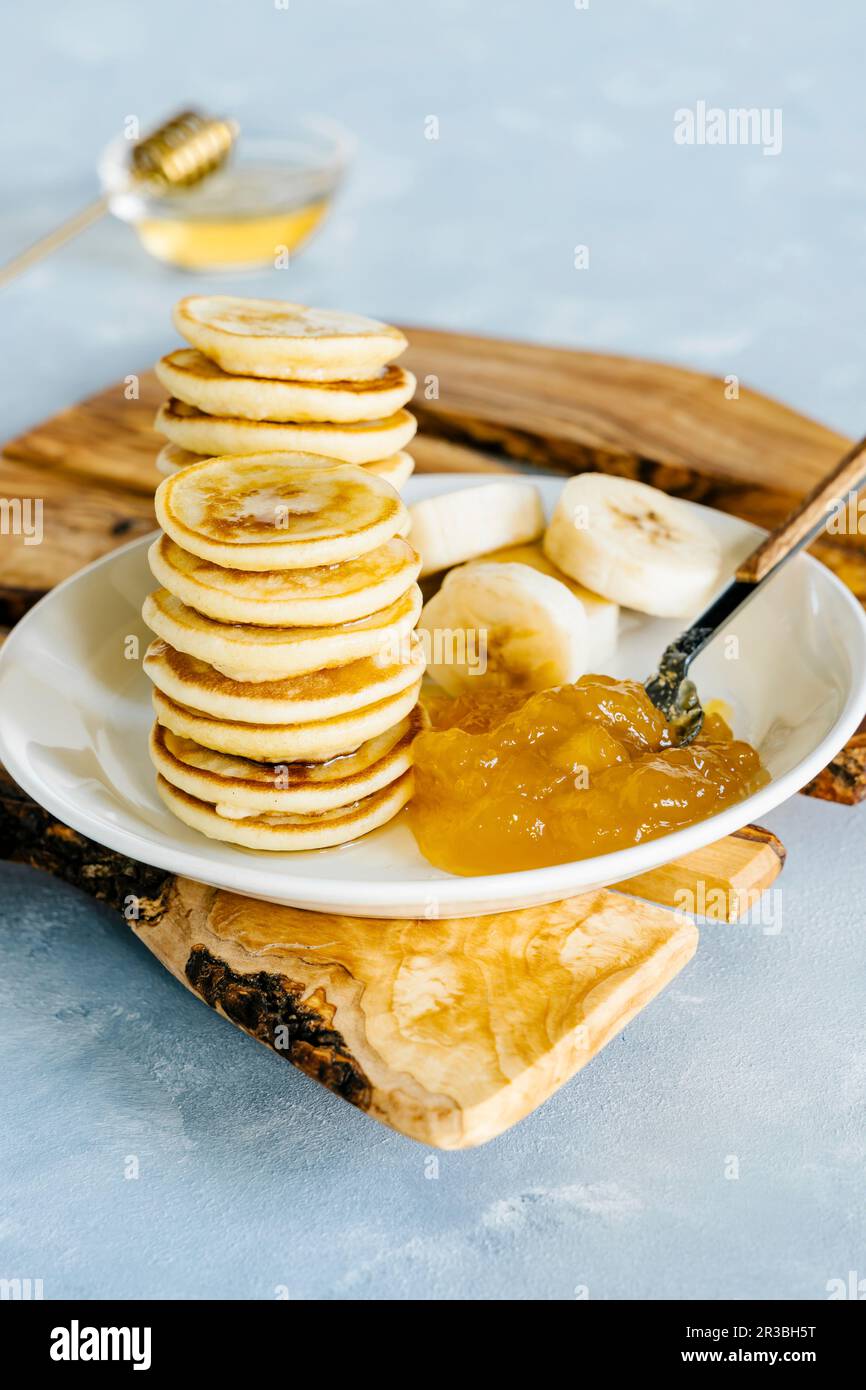Mini pancake con marmellata di ananas al mango e banana Foto Stock