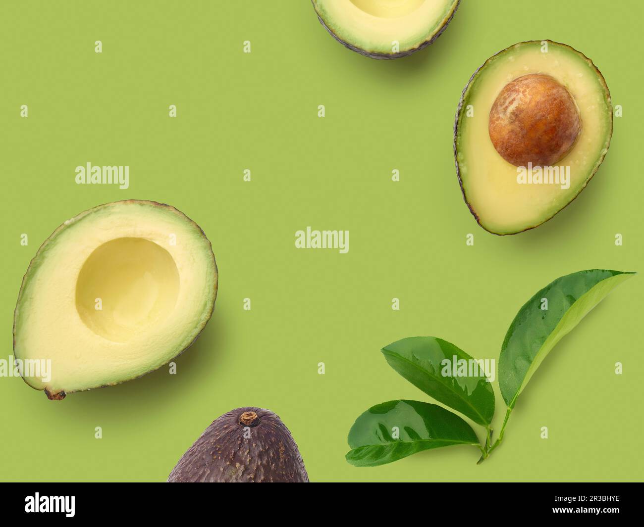 Avocado dimezzato su una superficie verde Foto Stock
