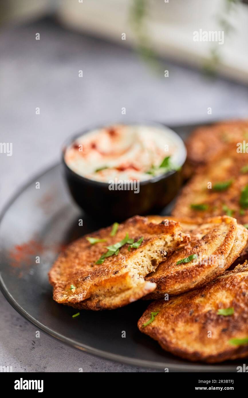 Frittelle vegetariane servite con salsa di yogurt Foto Stock