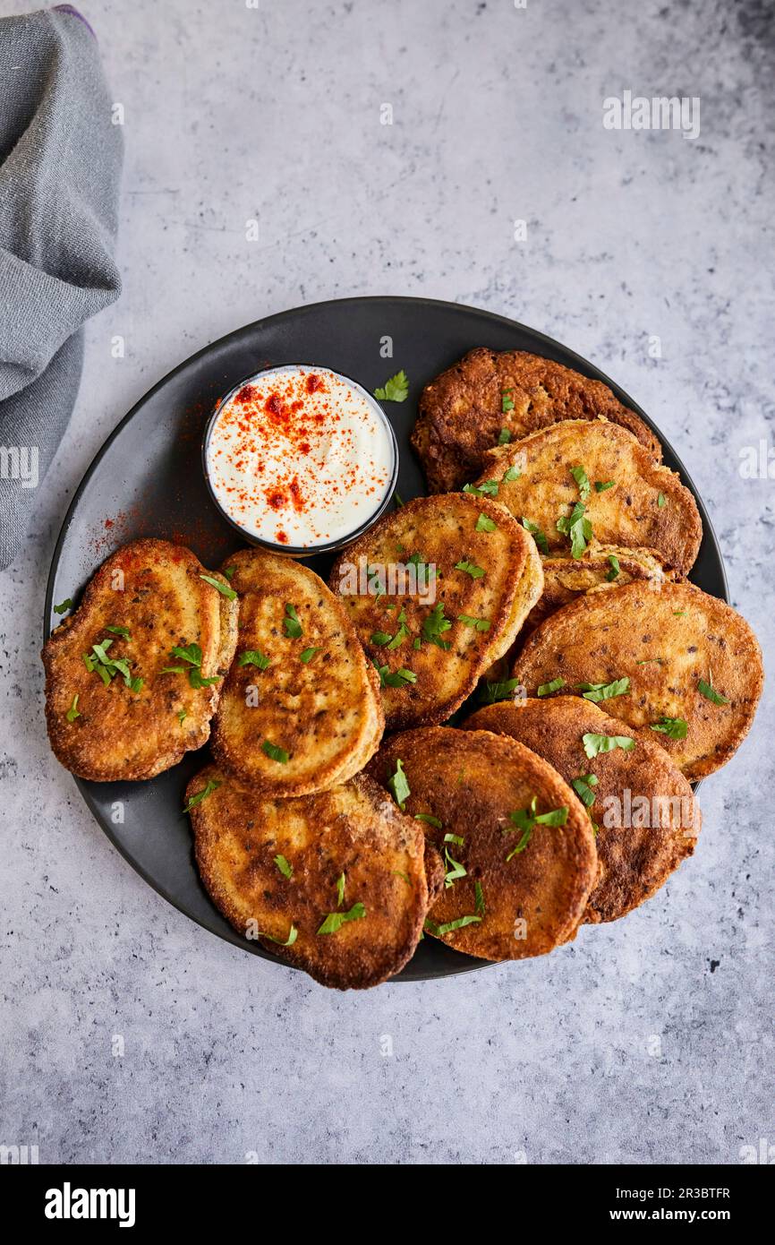 Frittelle vegetariane servite con salsa di yogurt Foto Stock