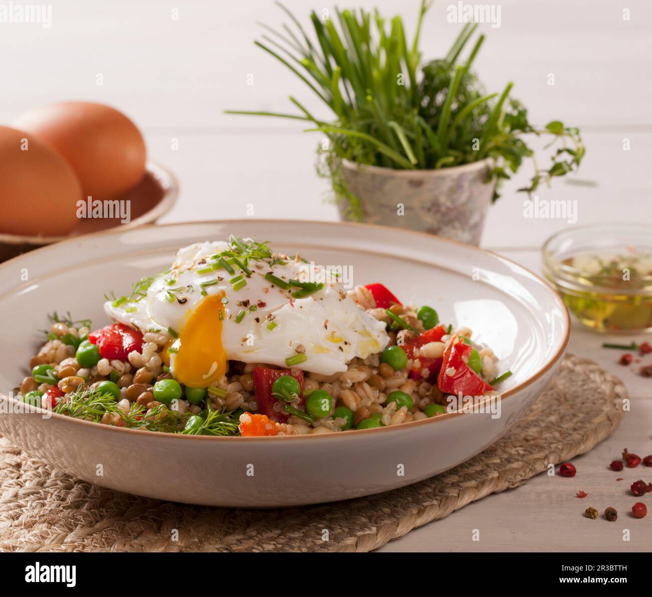 Uovo in camicia su un'insalata di grano con verdure Foto Stock
