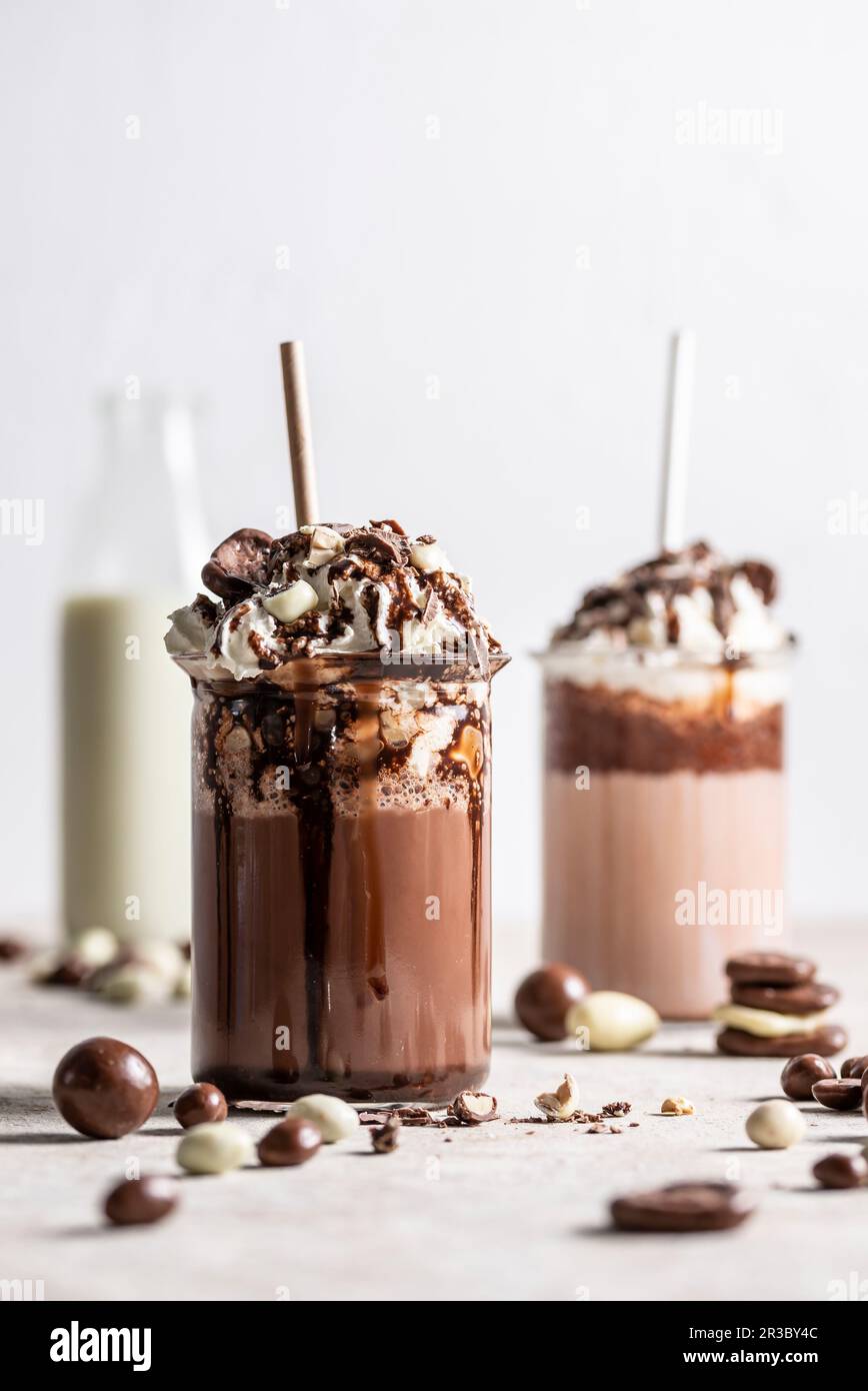 Frullati di cioccolato con panna montata e cioccolato e yogurt coperto di noci e uvetta Foto Stock