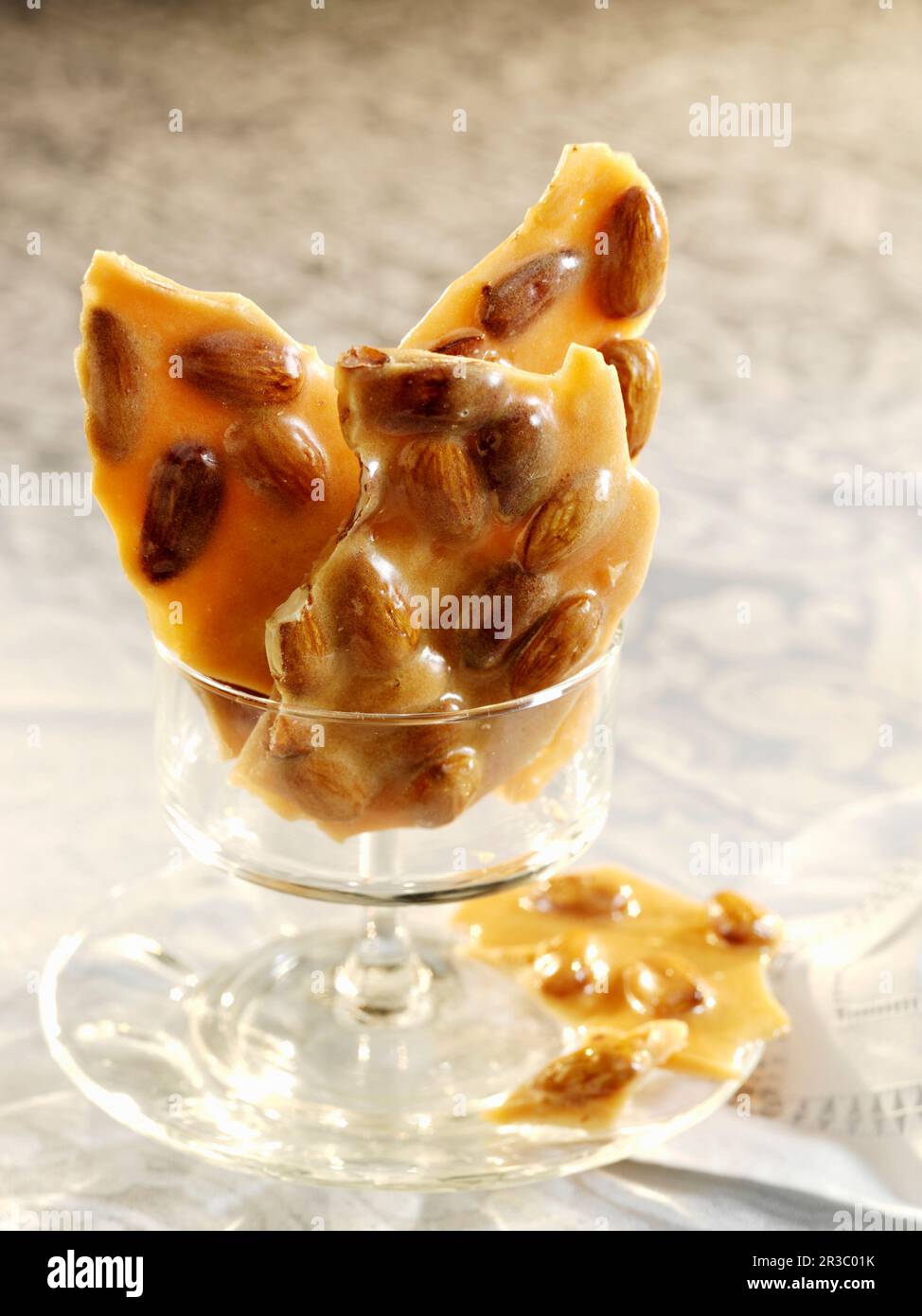 Pezzi di caramella fragile di mandorle in un piccolo piatto di vetro Foto Stock
