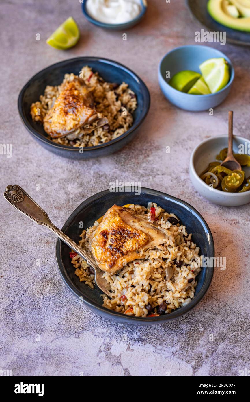 Una coscia di pollo con peperoni, riso e fagioli Foto Stock