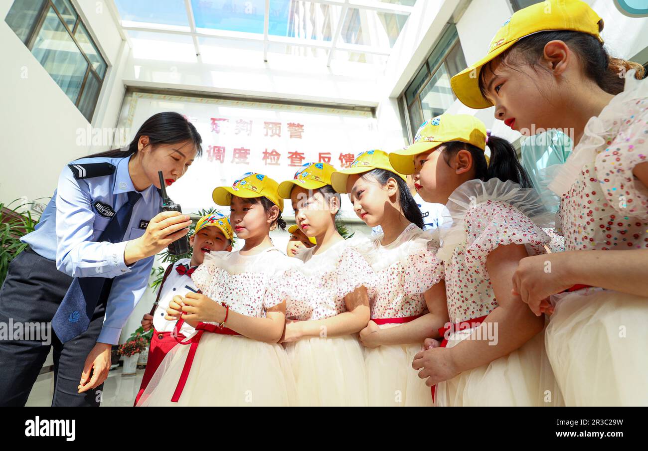 ZHANGYE, CINA - 23 MAGGIO 2023 - la polizia spiega l'uso dei walkie-talkie ai bambini in un asilo nella città di Zhangye, provincia di Gansu, Cina, 23 maggio, Foto Stock