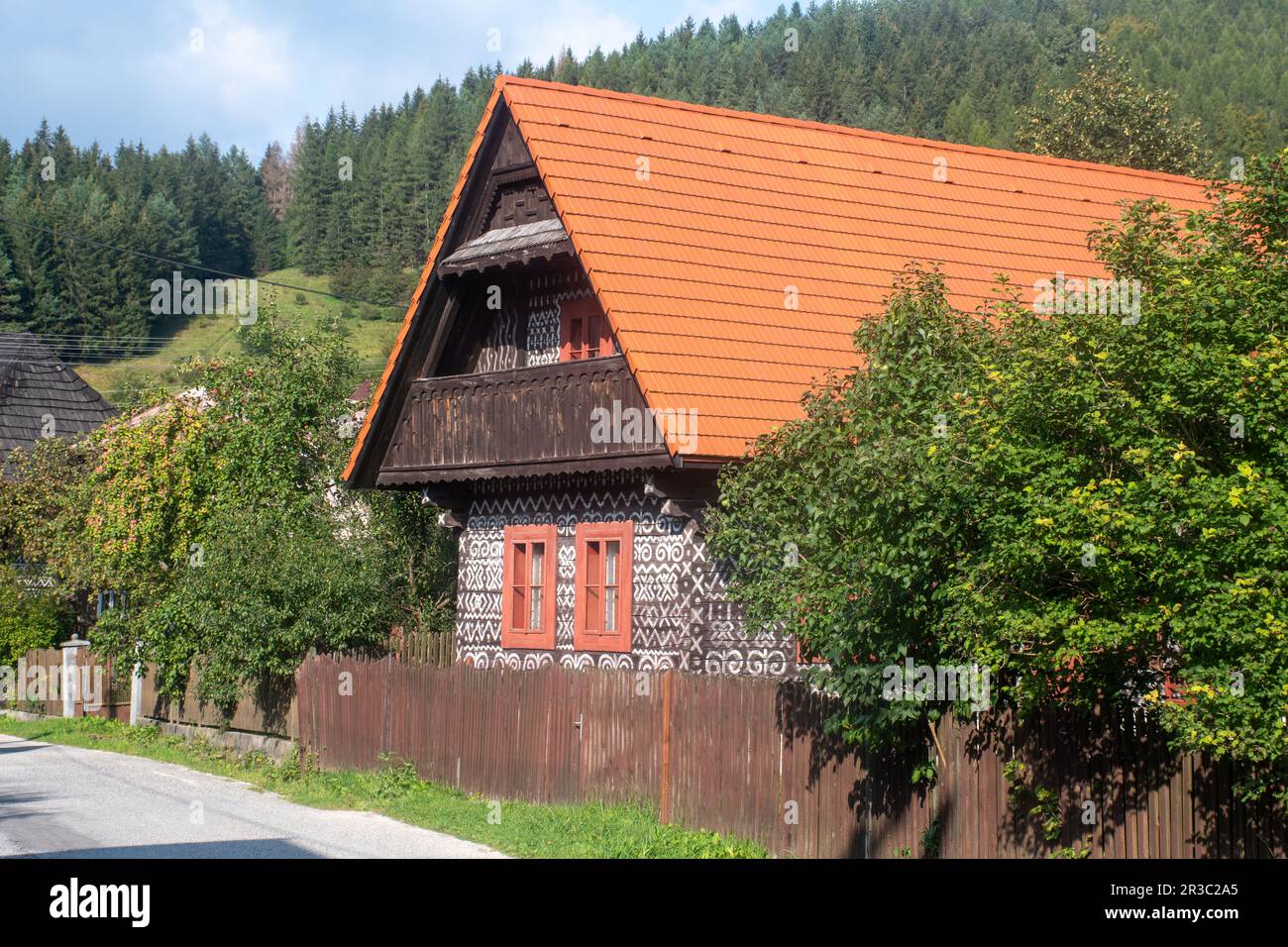 Casa decorata in bianco e nero nel villaggio popolare slovacco di Cicamany con colline sullo sfondo Foto Stock