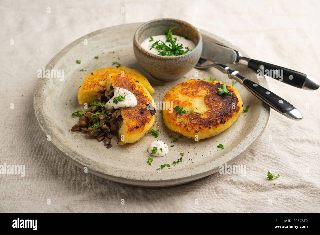 Frittelle di patate vegane con ripieno di funghi e salsa alle erbe Foto Stock