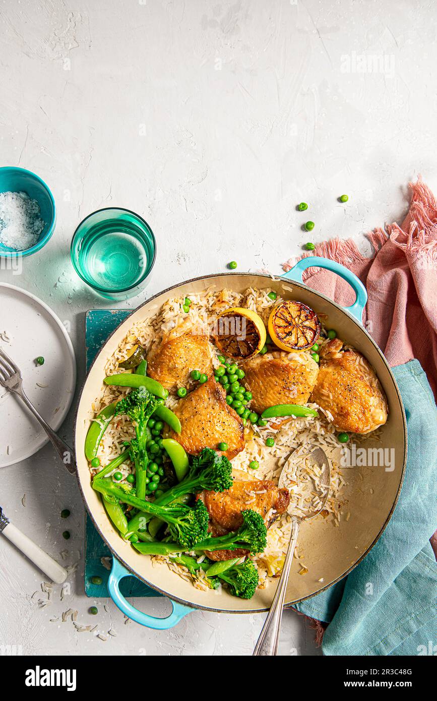il pollo si stringe con riso al limone, aglio e verdure primaverili Foto Stock