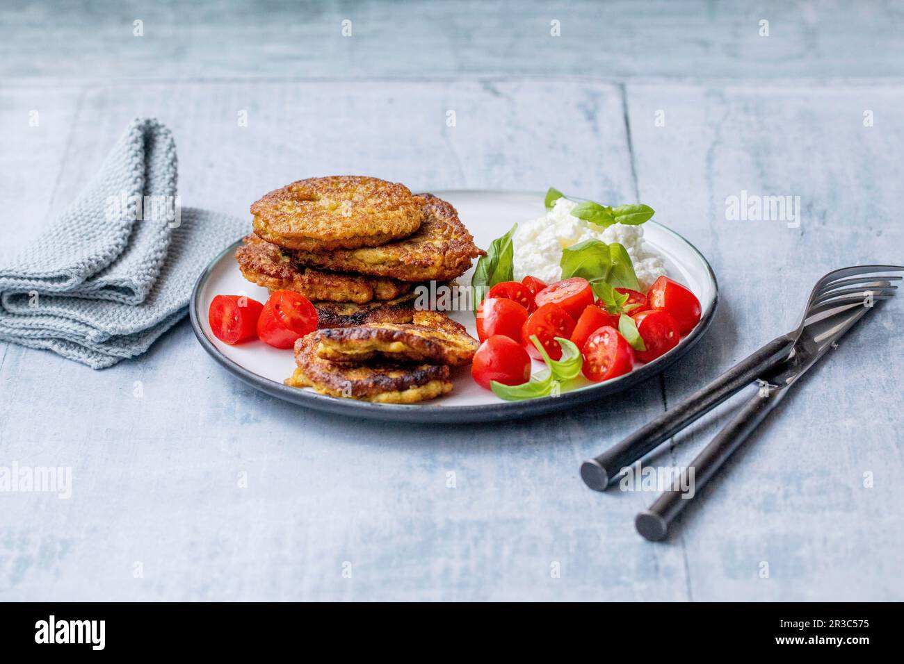 Frittelle di verdure con pomodori e formaggio cremoso grinoso Foto Stock