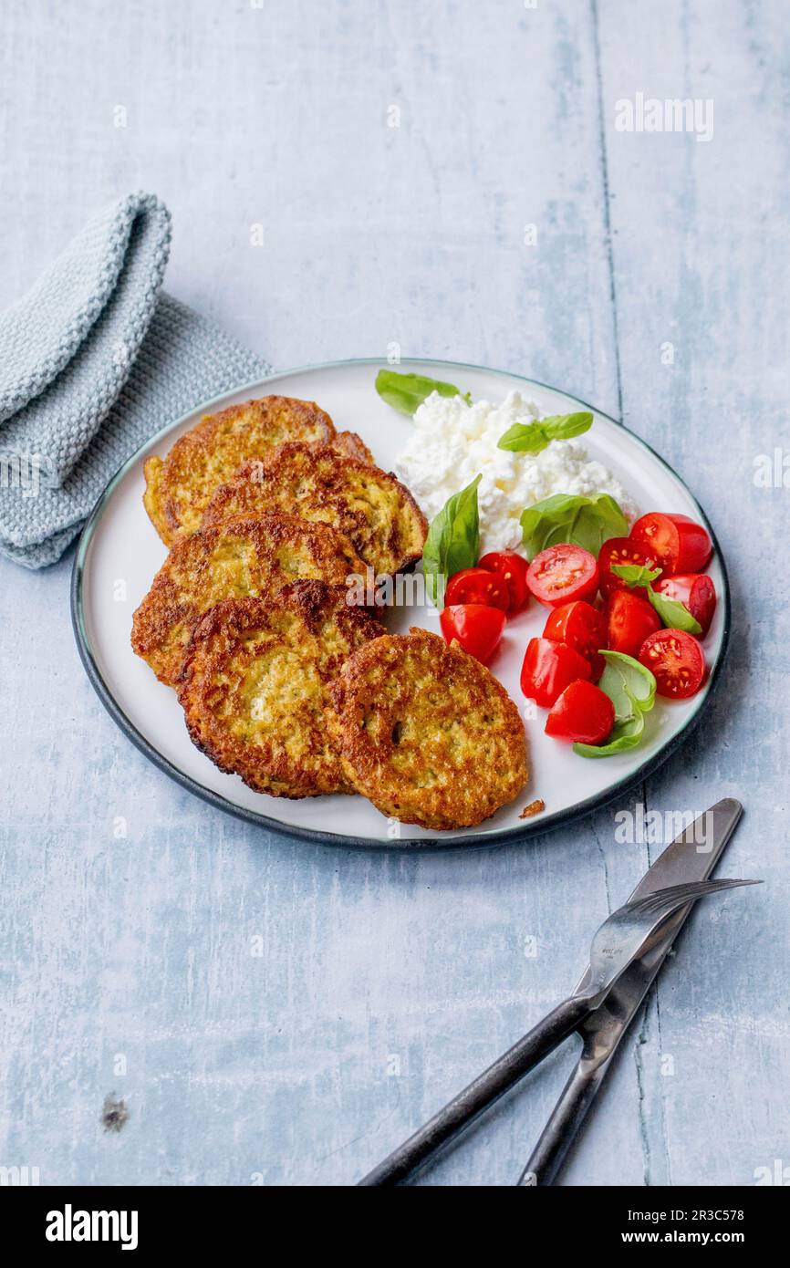 Frittelle di verdure con pomodori e formaggio cremoso grinoso Foto Stock