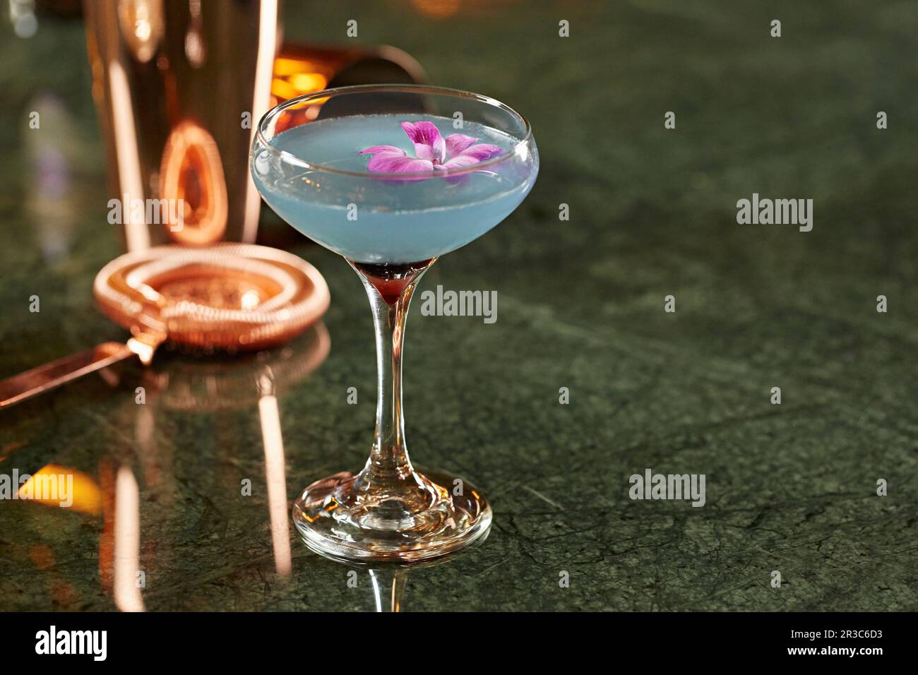 Un cocktail con una decorazione di fiori viola Foto Stock