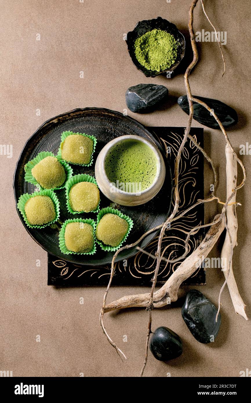 Dessert asiatico di riso dolce verde matcha mochi con tazza di tè matcha con schiuma. Giacitura piatta Foto Stock