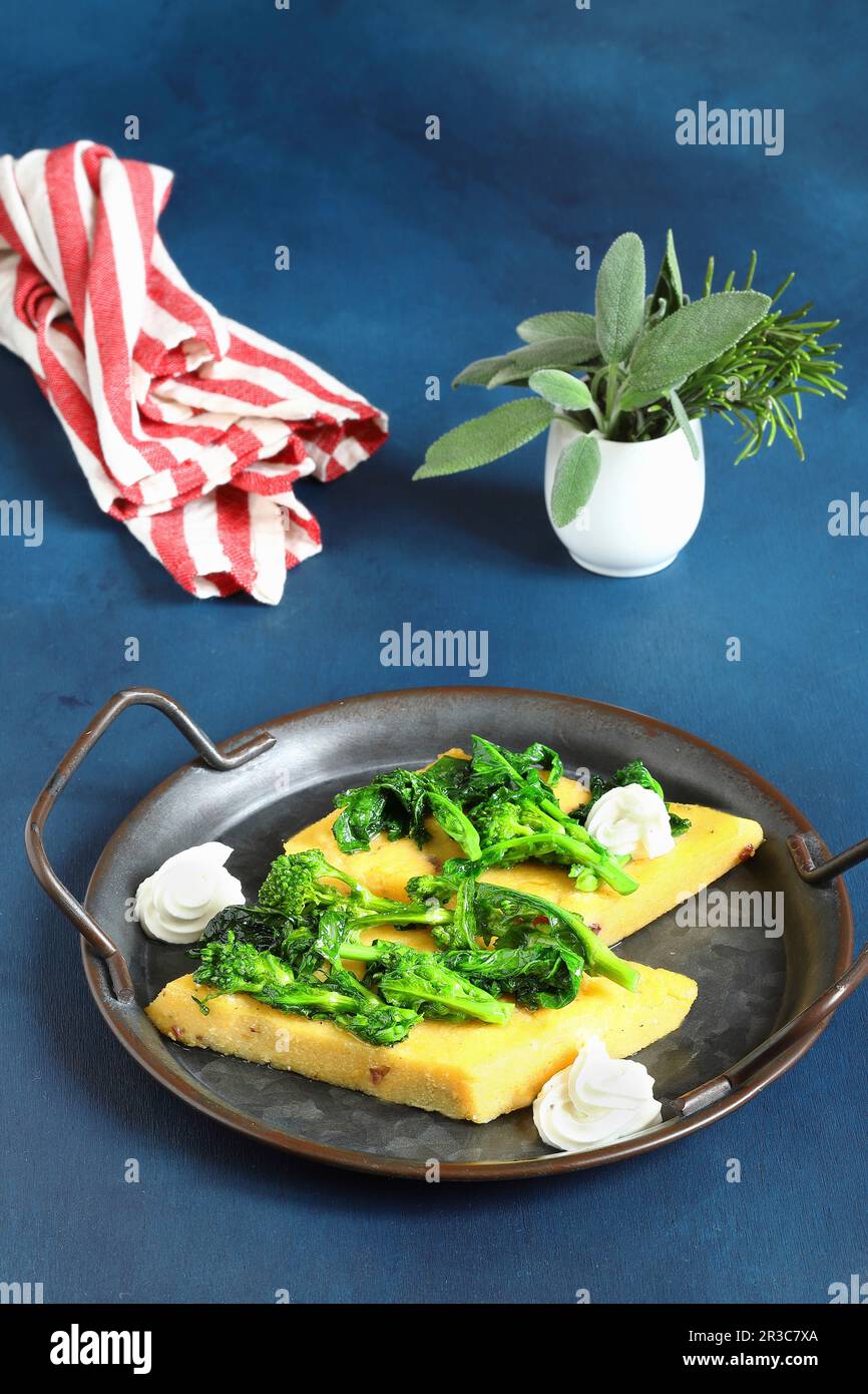 Crostini di polenta con broccolini e formaggio di capra Foto Stock