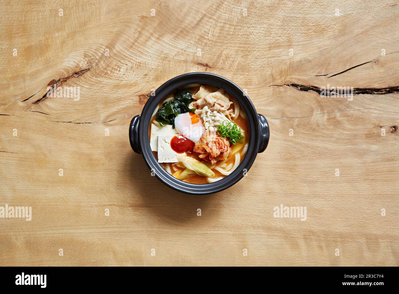 Ramen con tagliatelle di udon, kimchi, pollo, formaggio, uovo, alghe e funghi enoki Foto Stock