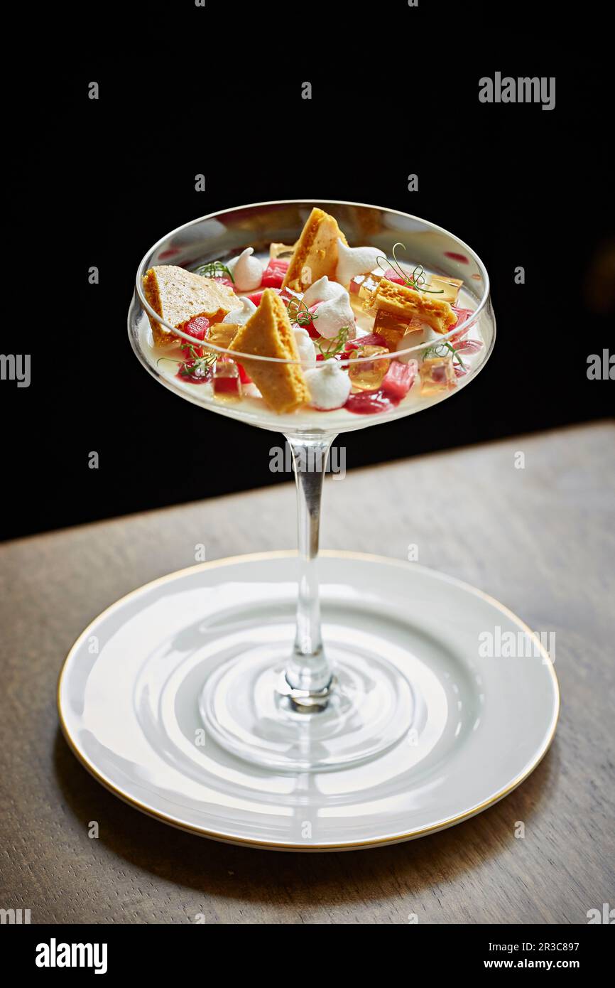 Un elegante dessert con rabarbaro, nido d'ape e meringa Foto Stock