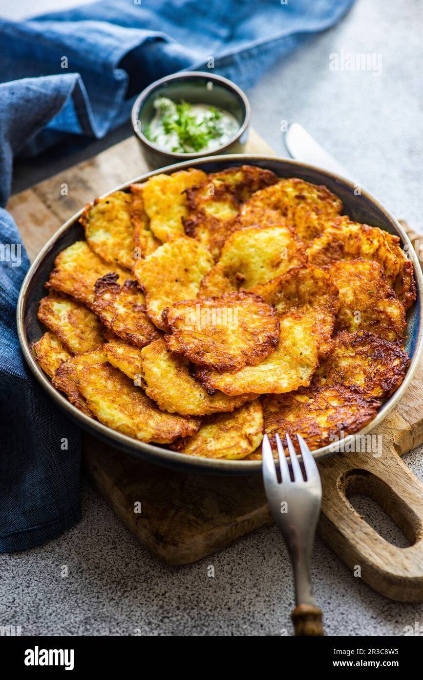 Frittelle di patate tradizionali ucraine servite con panna acida e aneto alle erbe Foto Stock