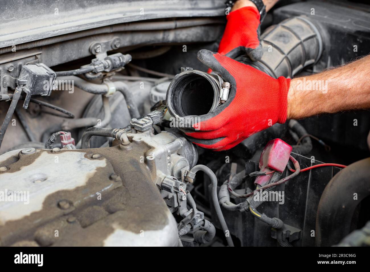 Il meccanico dell'auto ha scollegato il tubo dell'aria dal motore dell'auto. Riparazioni auto. Foto Stock