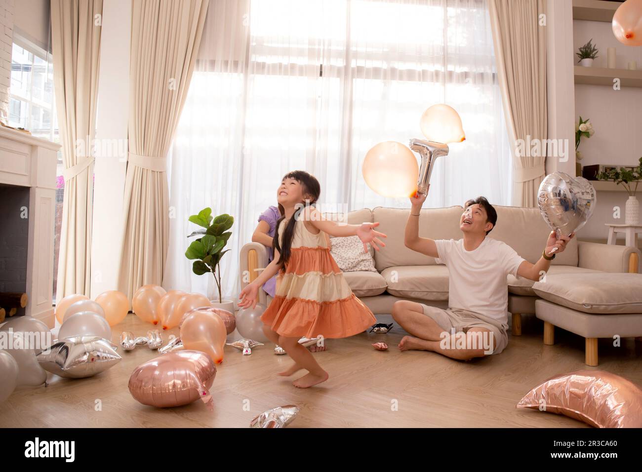 Felice famiglia asiatica padre e madre e figlia giocare mongolfiera con divertimento e la celebrazione nel soggiorno a casa, papà e mamma e bambino rilassarsi Foto Stock