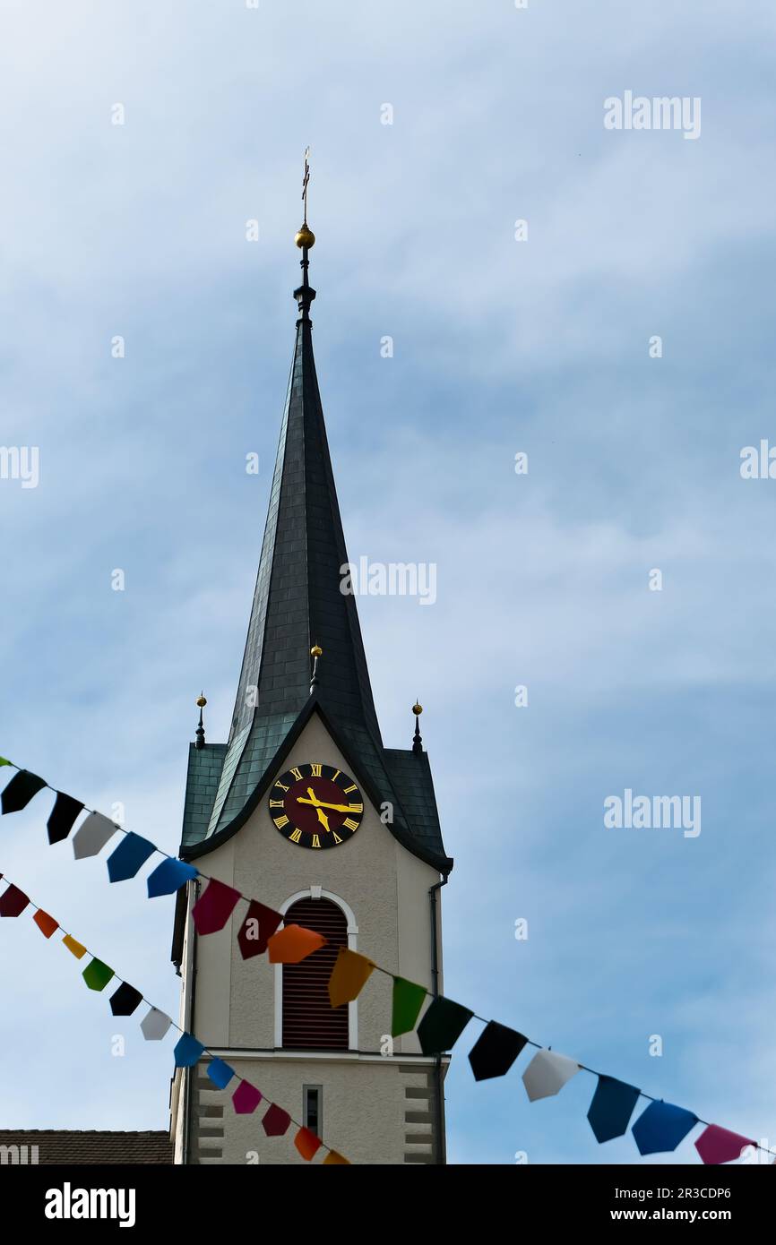 Una struttura torreggiante in cima ad una chiesa, spesso adornata con dettagli architettonici e una campana, che serve come un punto di riferimento prominente in una comunità. Foto Stock