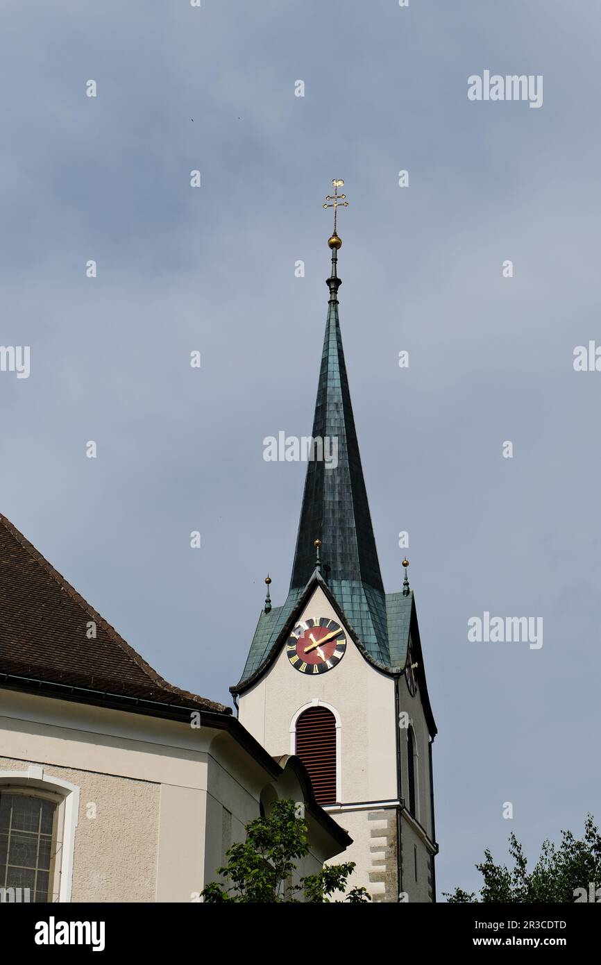 Una struttura torreggiante in cima ad una chiesa, spesso adornata con dettagli architettonici e una campana, che serve come un punto di riferimento prominente in una comunità. Foto Stock