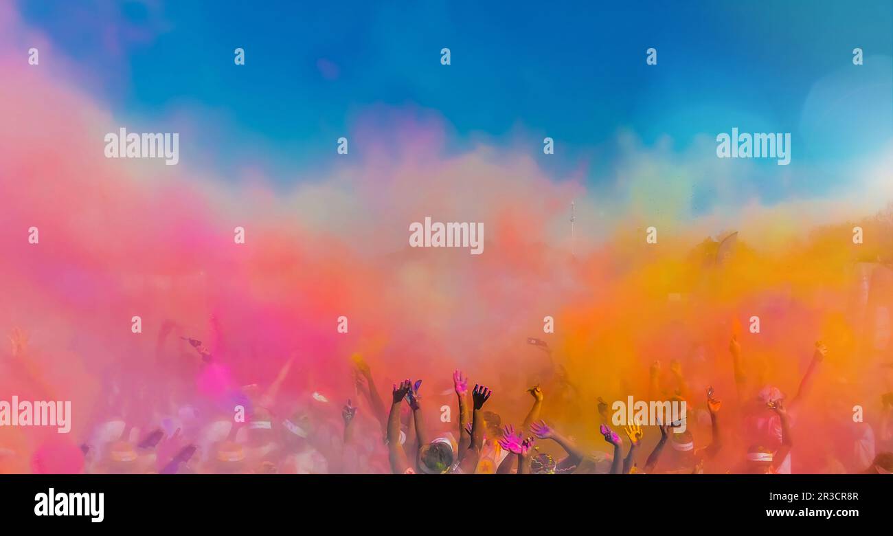 La folla gettando luminose colorate di vernice in polvere in aria, Holi festival Dahan Foto Stock