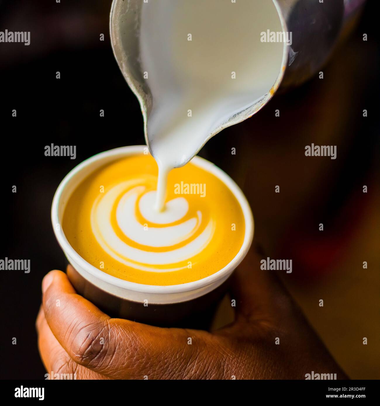 African Coffee Barista versare una forma di foglia con schiuma di latte Foto Stock