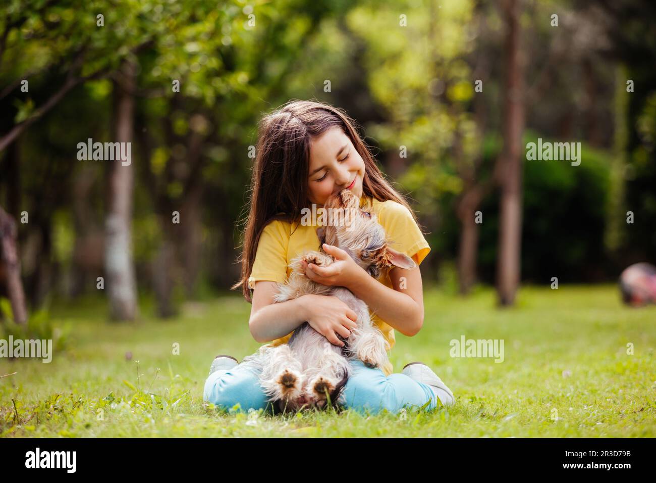 La bambina carina con il cane Yorkshire terrier nel cortile Foto Stock