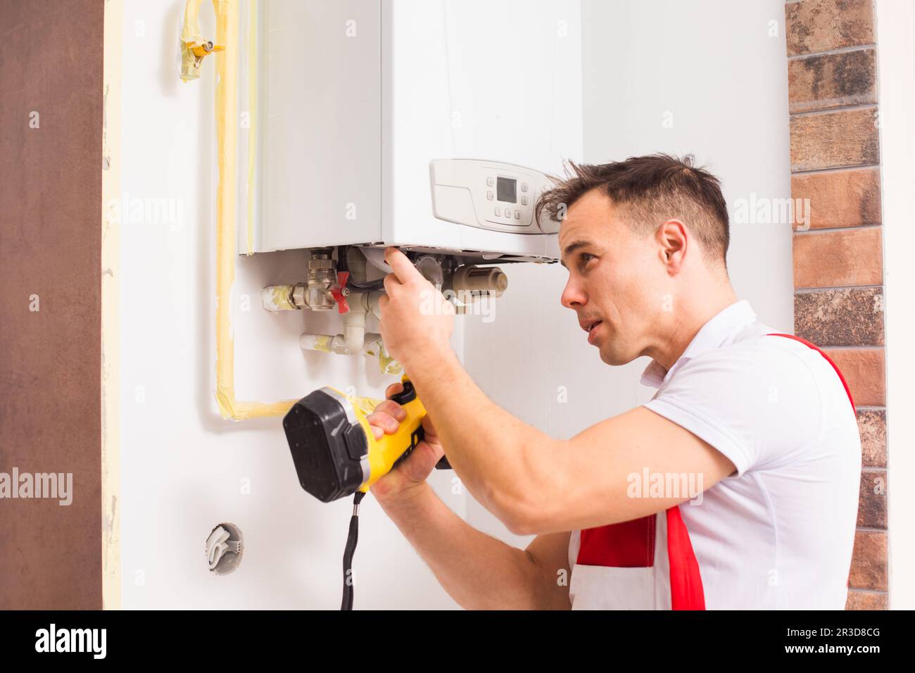L'idraulico ripara una caldaia in cucina Foto Stock