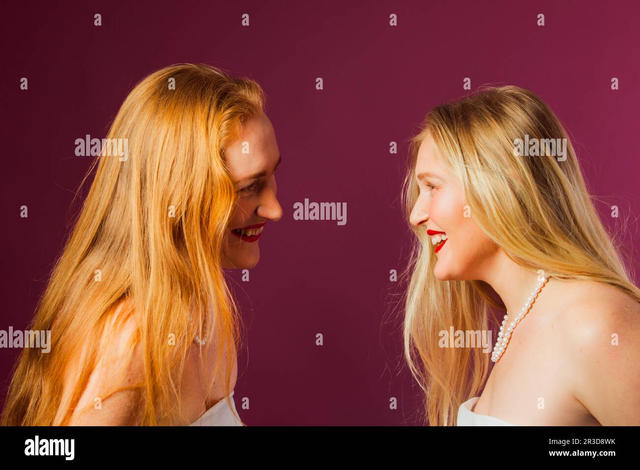Due donne che si levano in piedi l'una di fronte all'altra, toccando dalla testa Foto Stock
