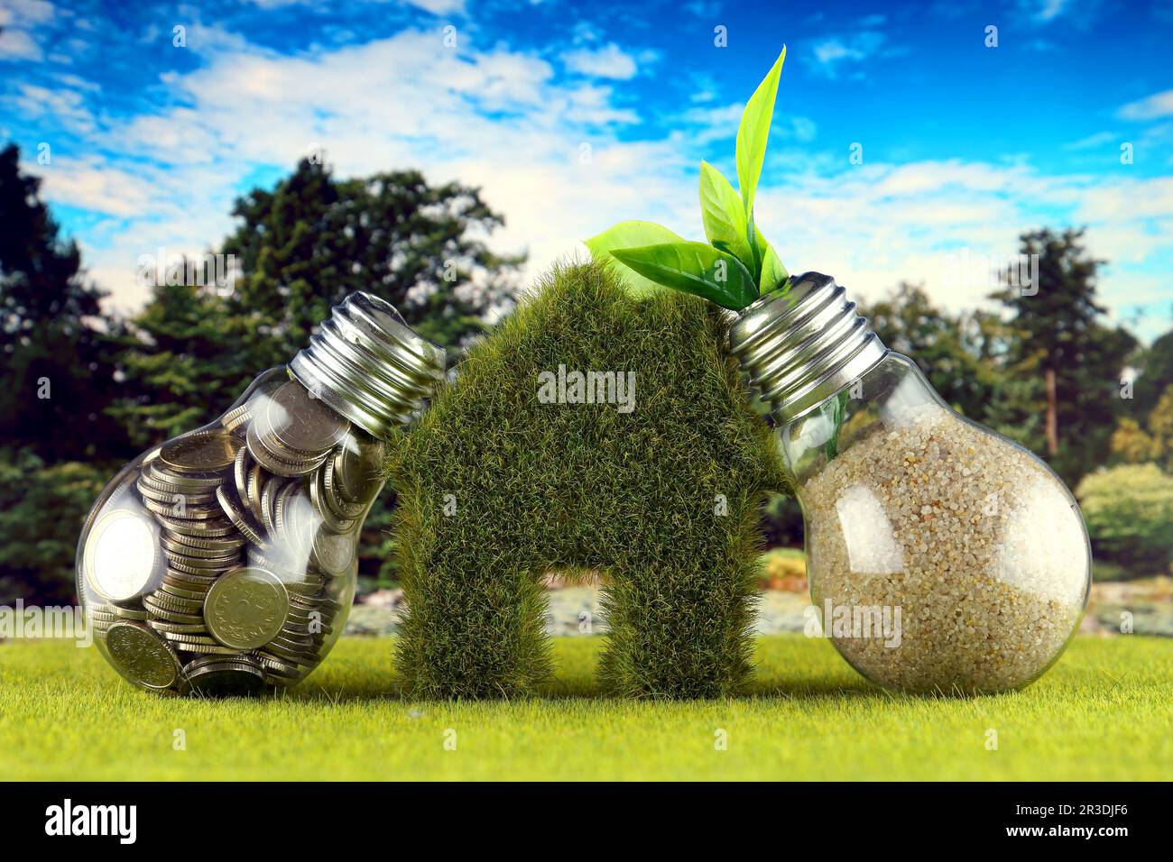 Monete all'interno della lampadina, pianta che cresce all'interno della lampadina e casa in miniatura con erba. Eco-verde energia rinnovabile concetto. Prezzo dell'elettricità Foto Stock