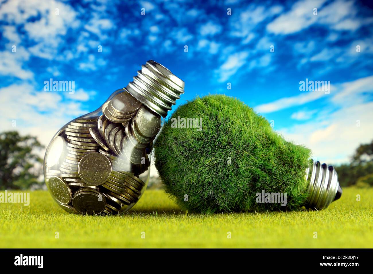 Monete all'interno della lampadina e lampadina verde eco con erba. Concetto di energia rinnovabile. I prezzi dell'elettricità, il risparmio energetico in famiglia. Foto Stock