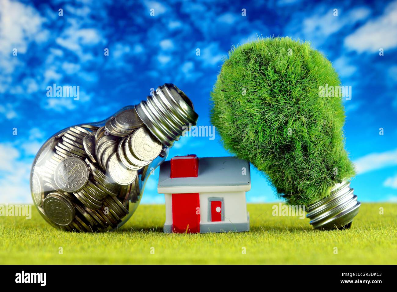 Monete all'interno della lampadina, lampadina verde eco con erba e casa in miniatura. Concetto di energia rinnovabile. I prezzi dell'elettricità, il risparmio energetico nelle ore Foto Stock