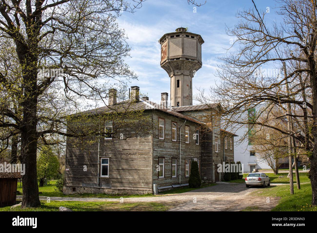 Derelict Bekker torre dell'acqua dietro vecchio edificio residenziale in legno fatiscente a Kopli 87 nel quartiere Kopli di Tallinn, Estonia Foto Stock
