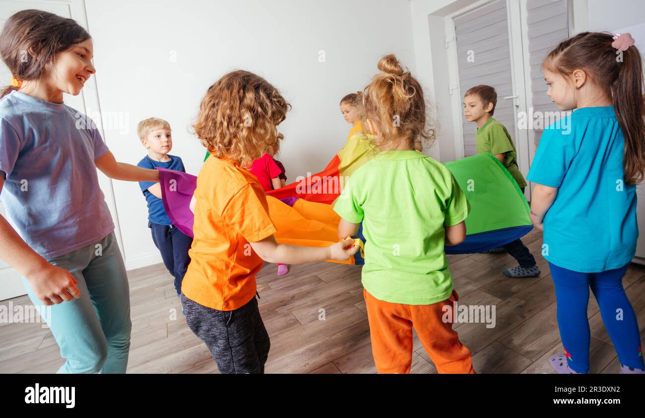 Giochi dinamici e di team building per bambini con tettoia colorata Foto Stock