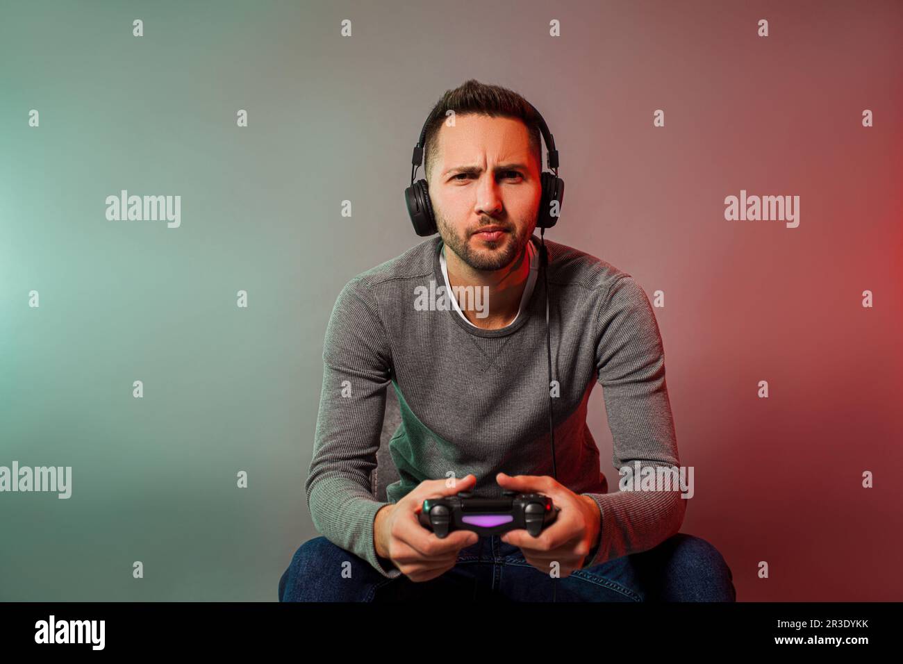 Uomo che tiene il joystick e gioca al gioco virtuale Foto Stock