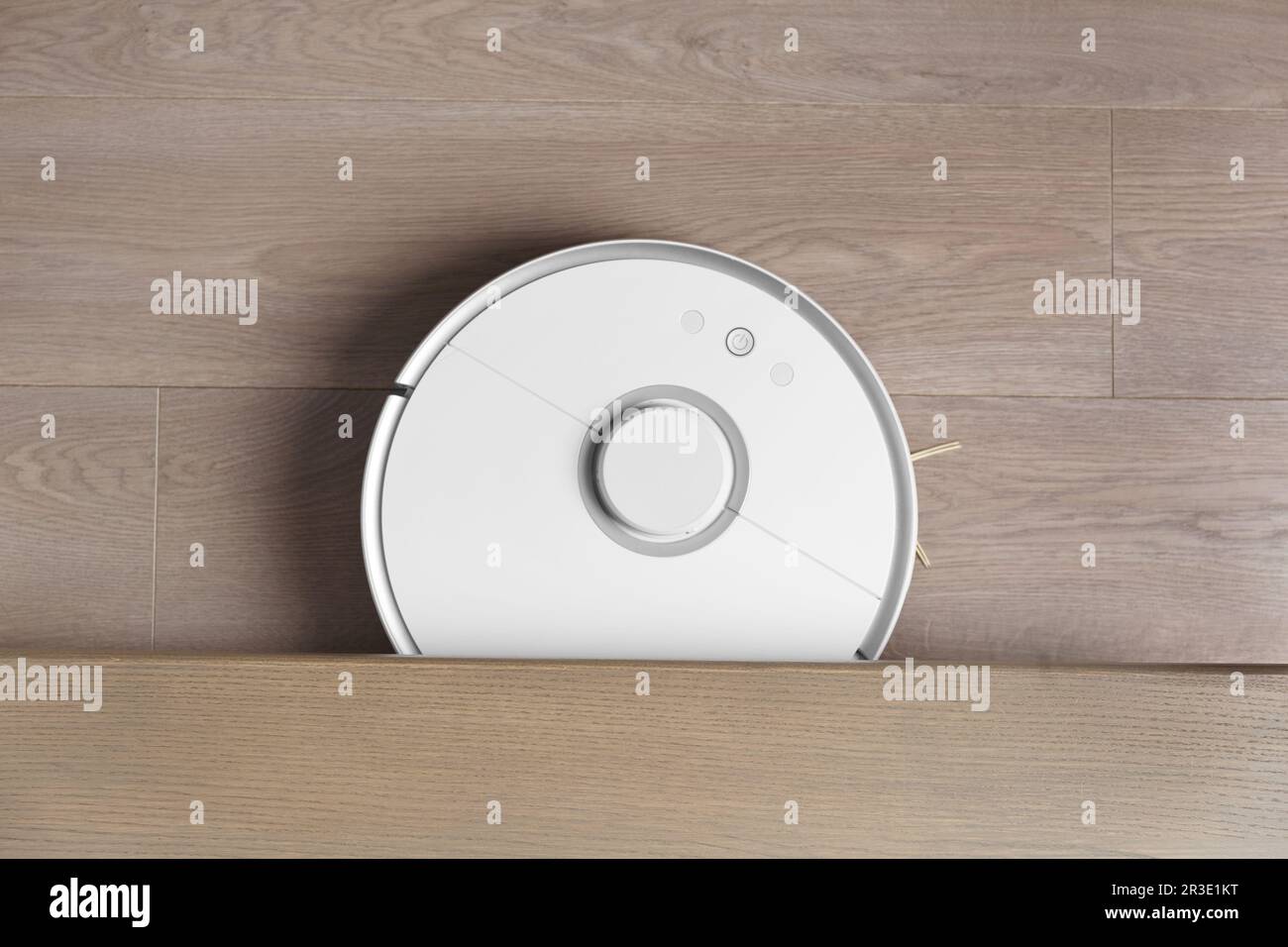 L'aspirapolvere robot intelligente pulisce il pavimento laminato, vista dall'alto. Il concetto di casa intelligente, pulizia wireless di qualsiasi superficie, casa elettronica Foto Stock