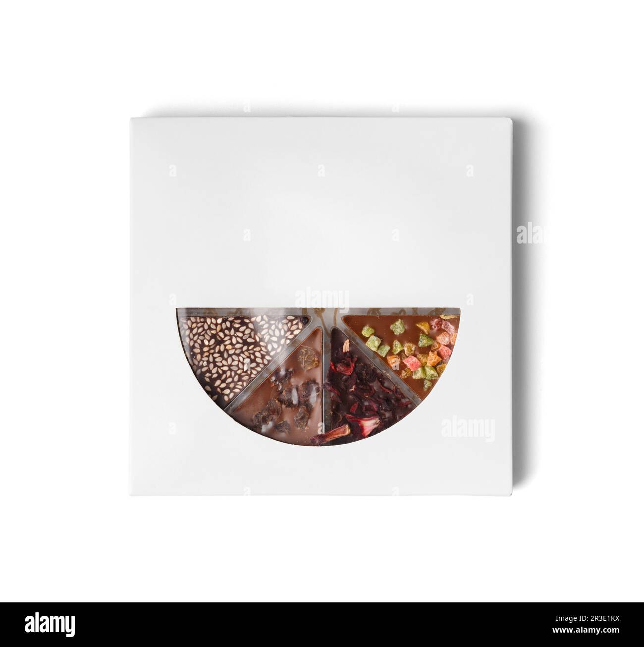 Dessert al cioccolato in forma di pizza con diversi condimenti nel pacchetto. Pizza al cioccolato a base di cioccolato nero e latte con canditi di frutta Foto Stock
