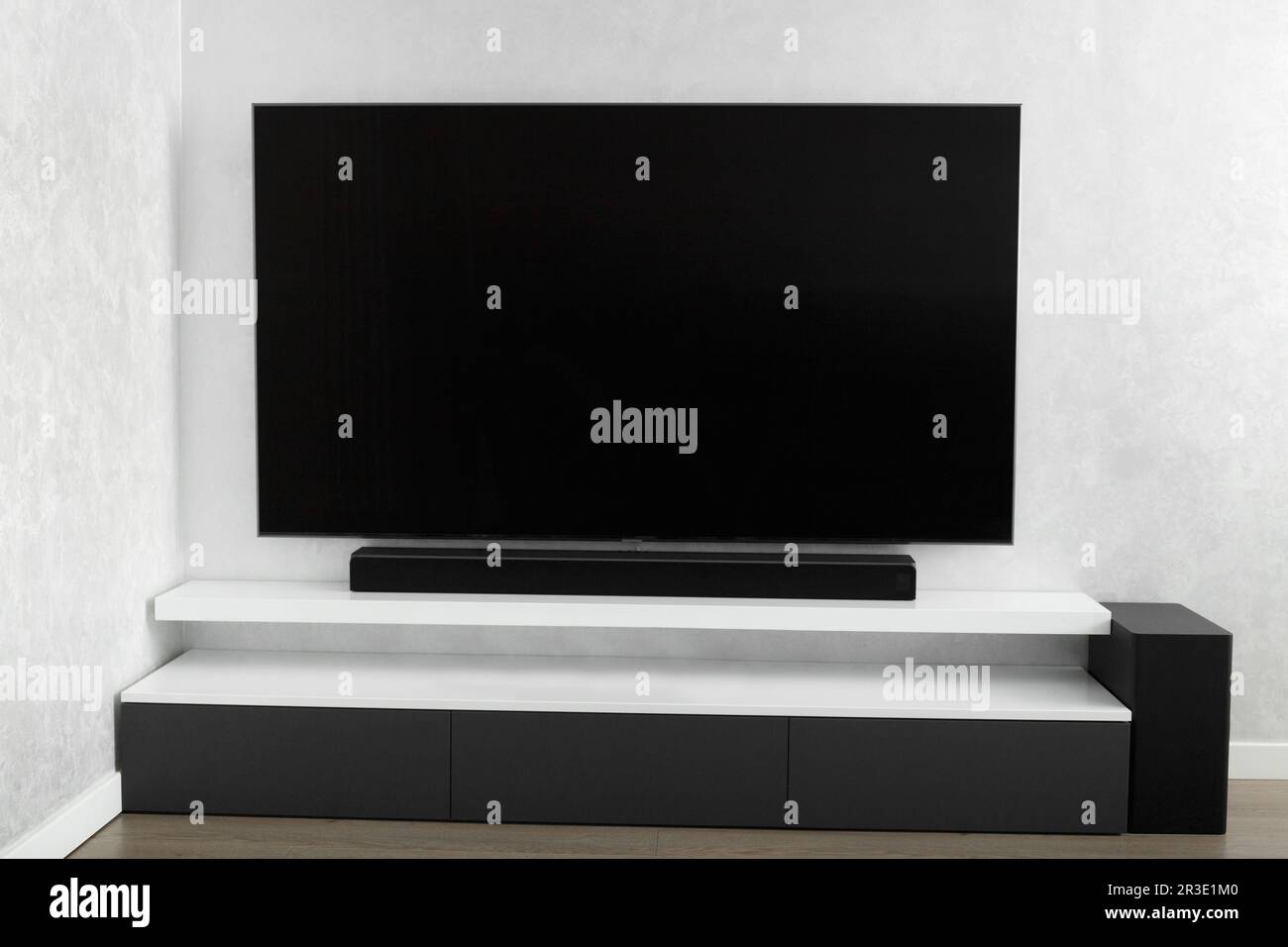 Parte interna del soggiorno con TV a parete, impianto stereo, Sound bar, cabinet grigio. TV e sistema musicale all'interno. Foto Stock