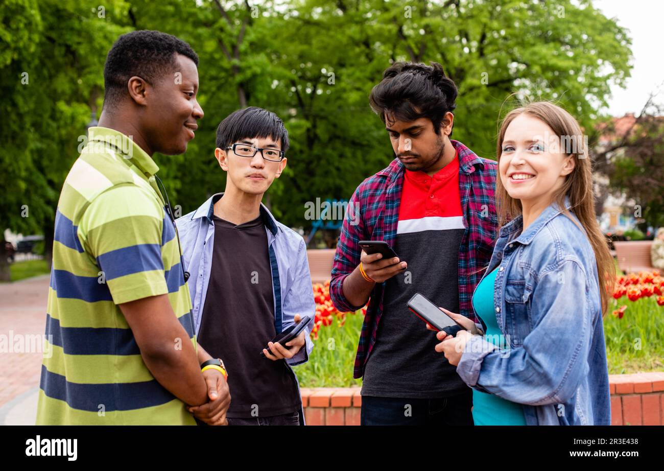 Comunicazione senza confini tra allegri studenti multietnici Foto Stock