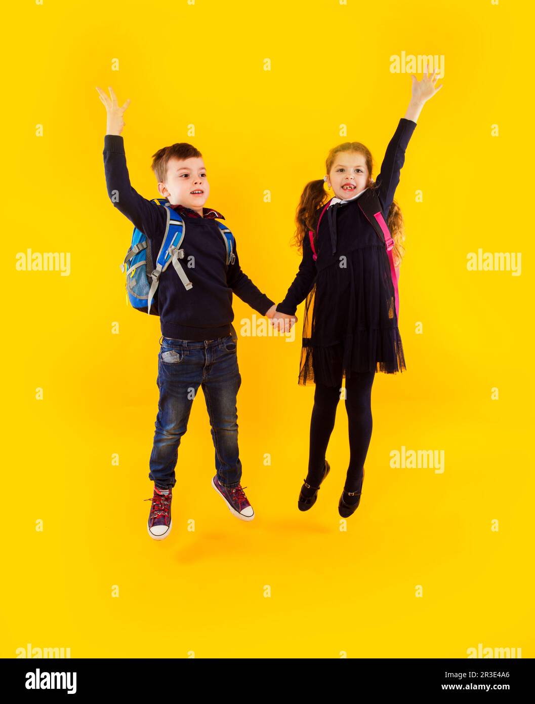 La coppia di compagni di classe sta saltando e tenendo le mani Foto Stock