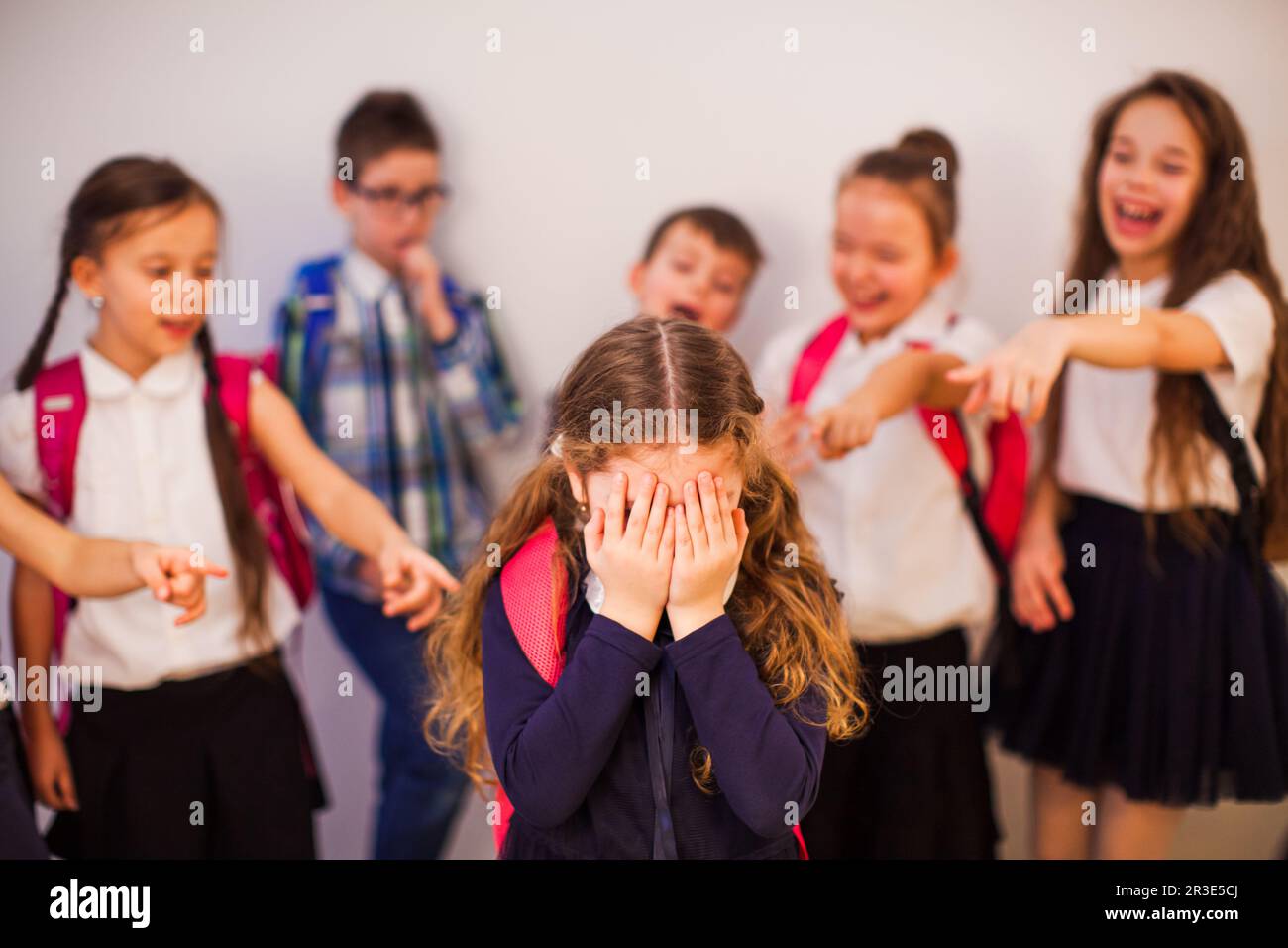 I compagni di classe indicano il ragazzo e lo ridono Foto Stock