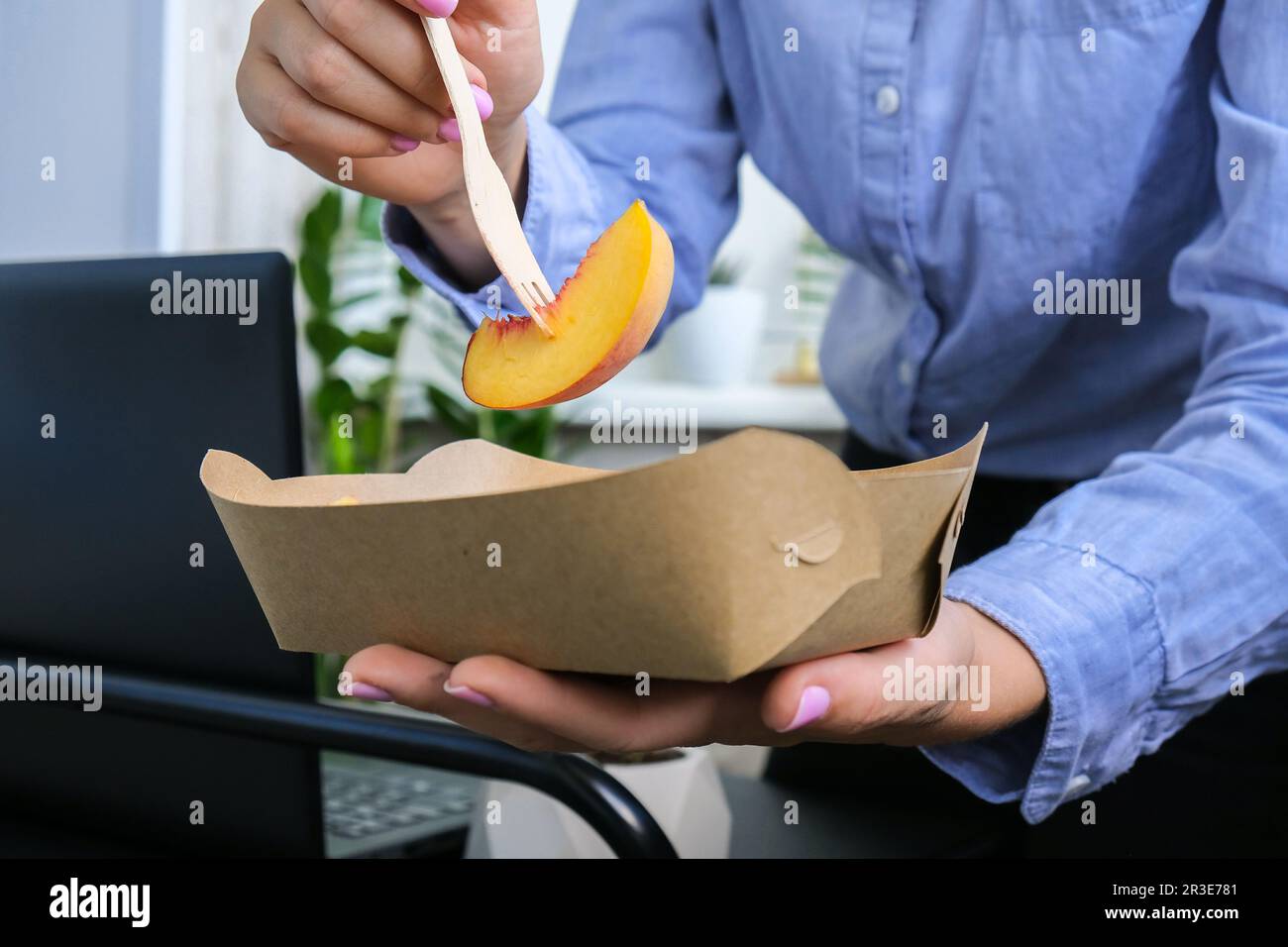 Una donna d'affari che ha una pausa pranzo sana dalle scatole da pranzo ecologiche consegnate. Delizioso concetto di cibo equilibrato. Ufficio domestico. Scheda ECO Foto Stock